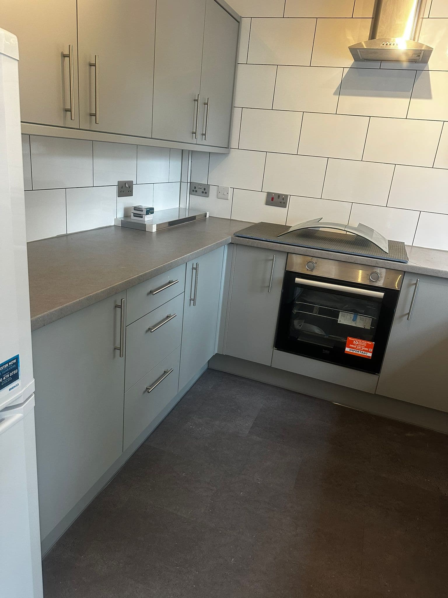 Freshly decorated commercial room with grey walls, green carpet and curtain rail