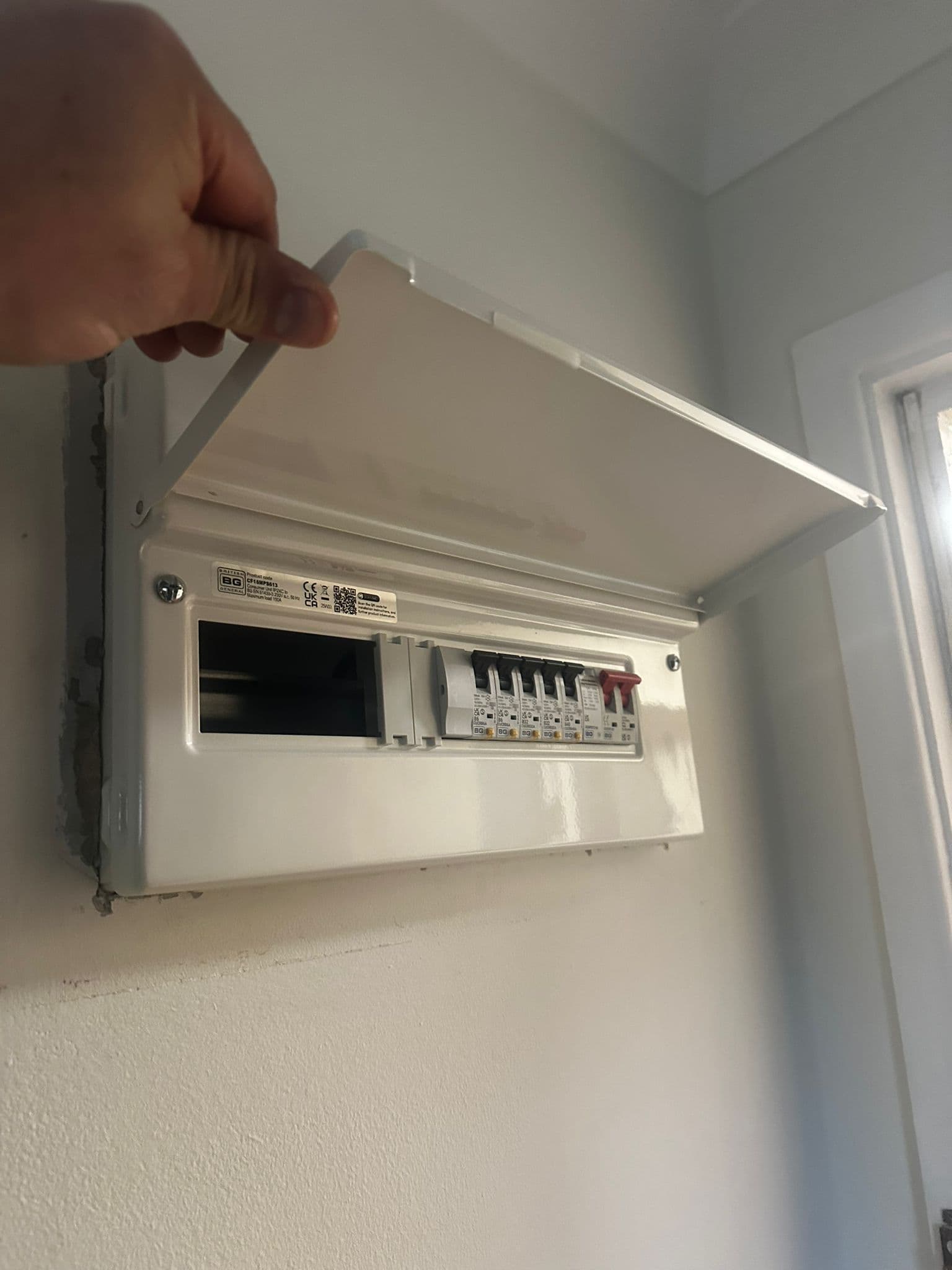 New consumer unit and fuse board installed on wall with lid open showing MCBs