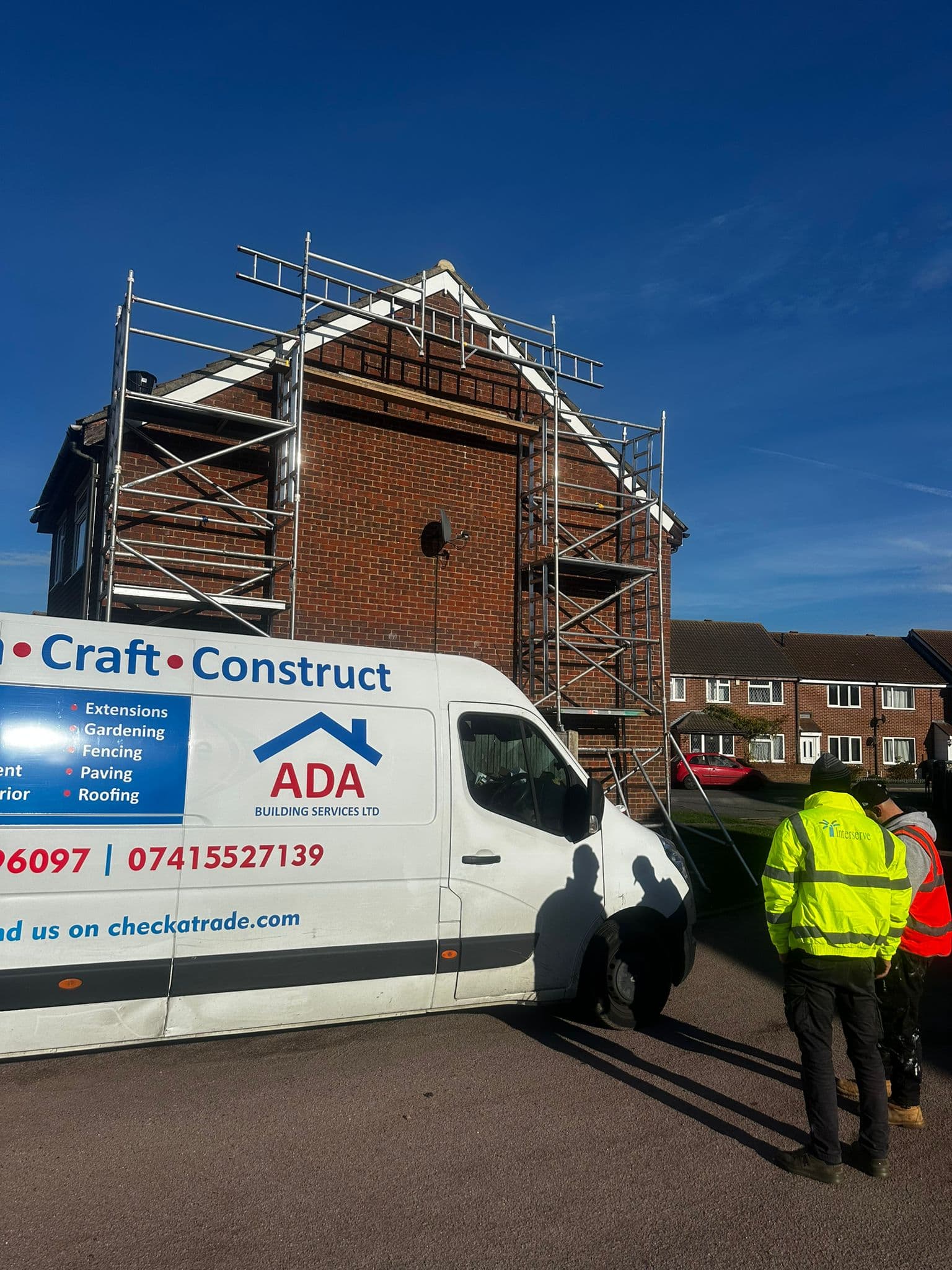 Ada Building Services van at job site with scaffolding on gable end and workers in hi-vis